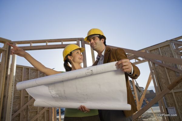 Young couple examining blueprint in construction site