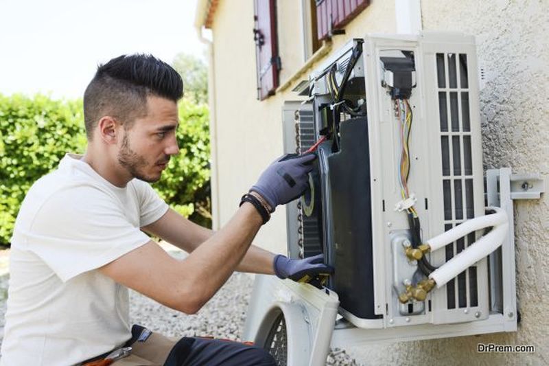 handsome young man electrician installing air conditioning in client house