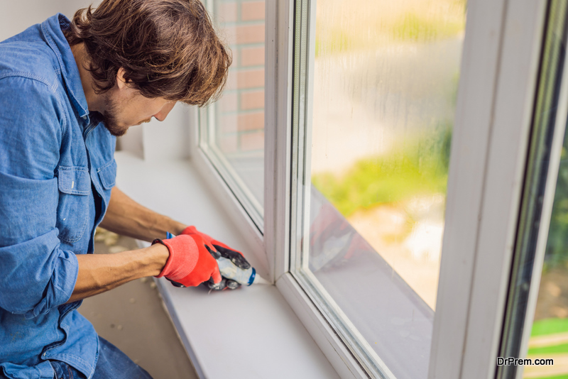 Man in a blue shirt does window installation